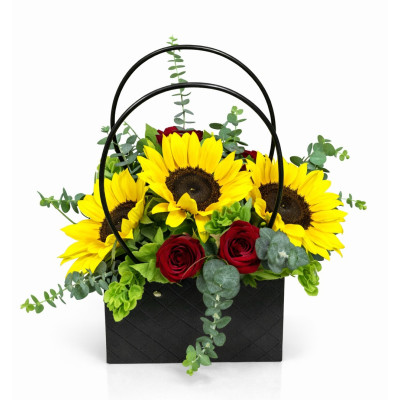 Hermoso arreglo floral con girasoles amarillos y rosas rojas en elegante cartera negra decorativa. Flores naturales frescas, ide