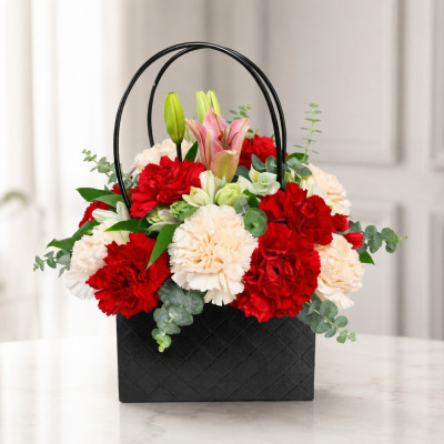 Elegante cartera negra decorativa con flores surtidas naturales en tonos vibrantes.