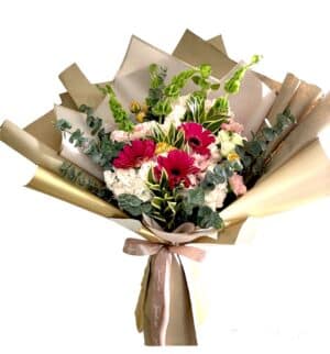 Espectacular composición floral Hortensias, Gerberas, claveles y flores tropicales, acompañadas de verdes y variedad de papeles florales. Incluye tarjeta personalizada